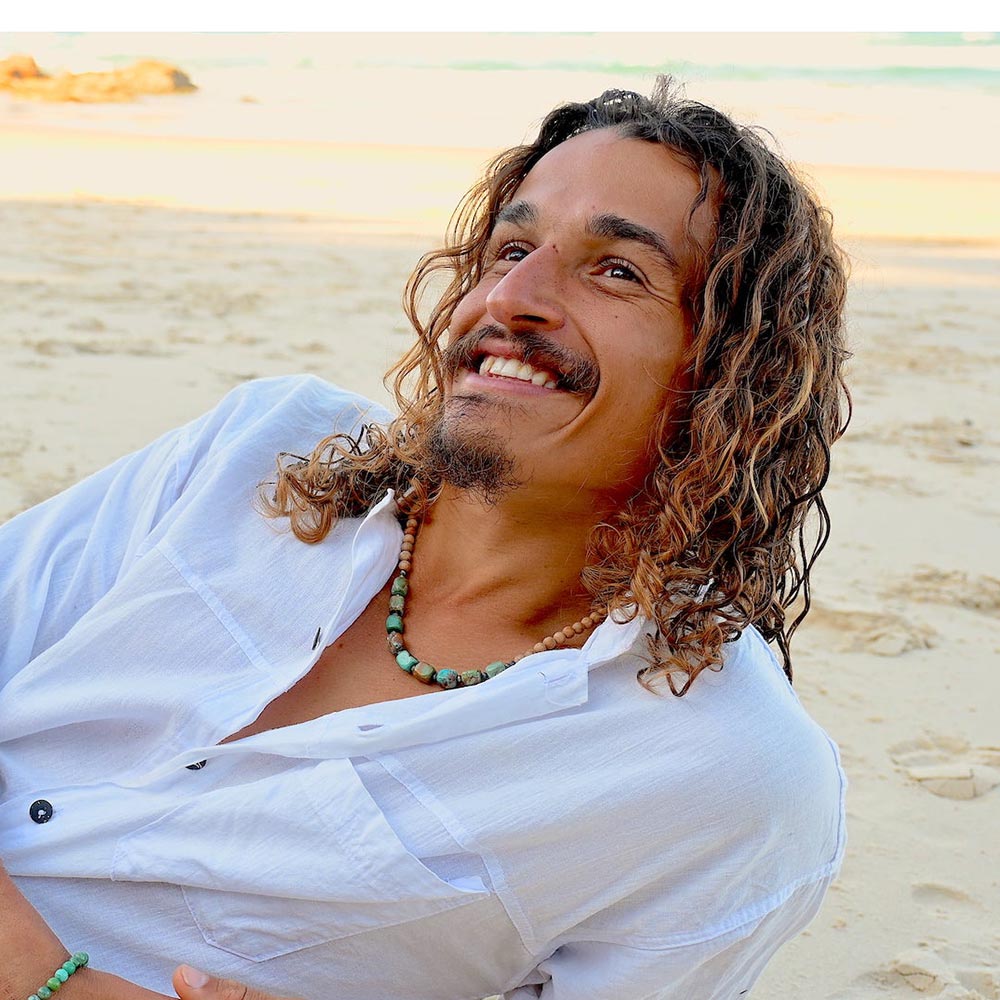 Mana for Men model wearing an Intentional Men's Turquoise beaded necklace with wooden accents, symbolizing purpose and personal transformation, worn close to the heart for emotional strength.