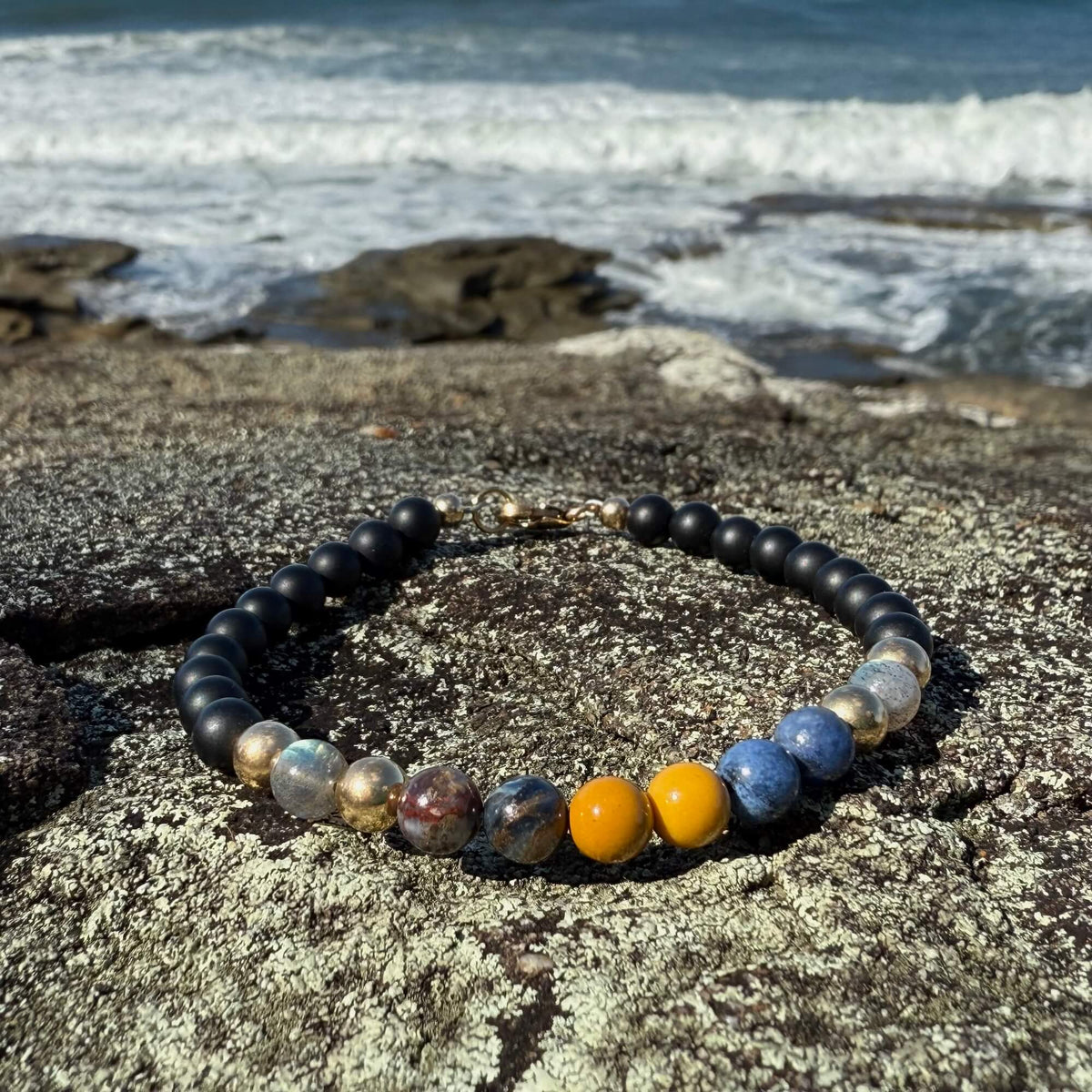 Mookaite and dumortierite beads on the Phoenix Rising bracelet, by the sea