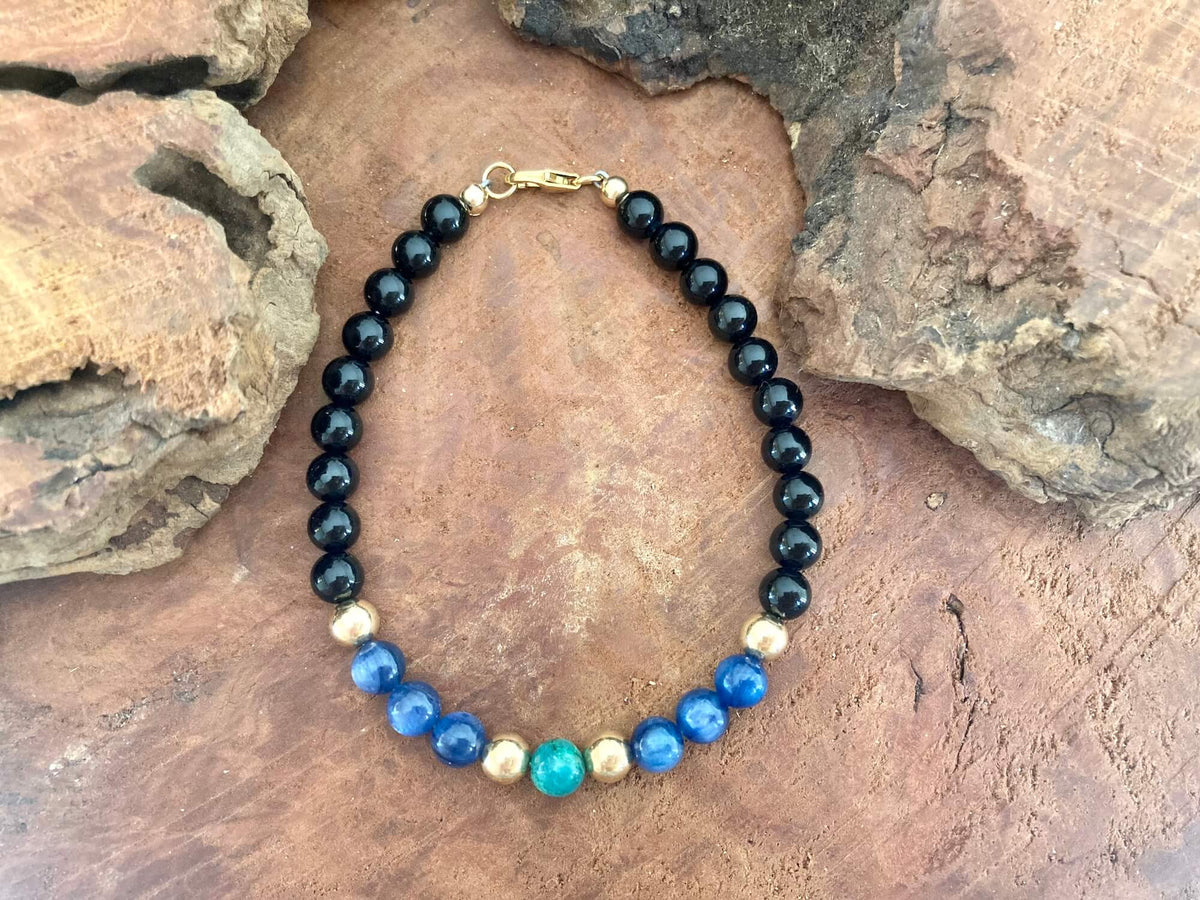 The Alchemist bracelet from above on a stone slab