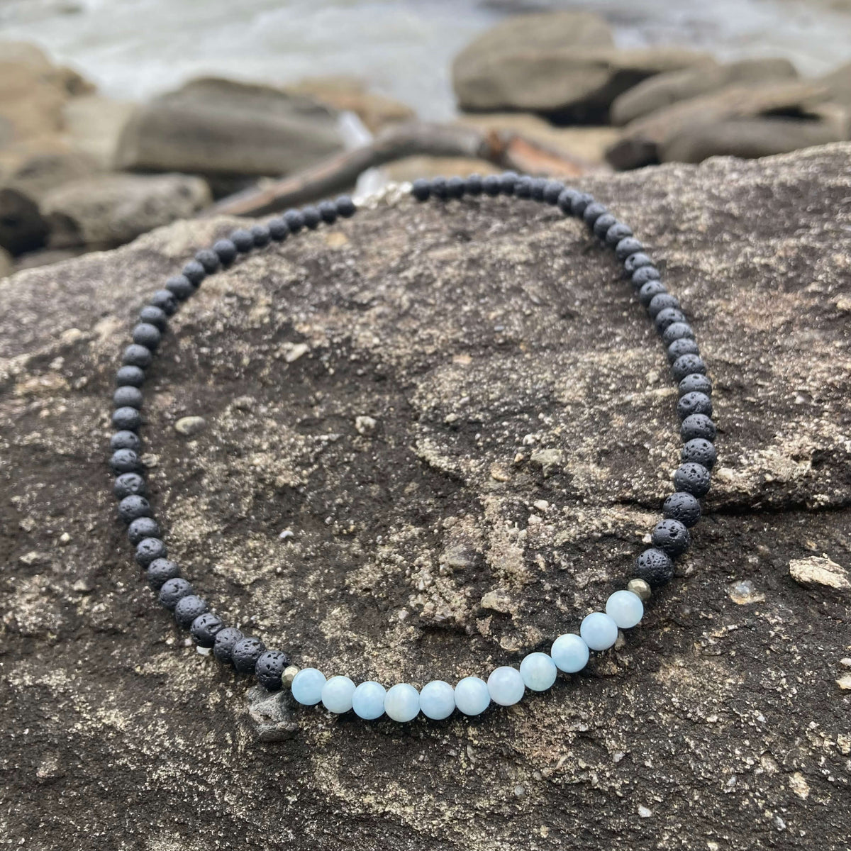 Aquamarine section of the Courage necklace on dark rock