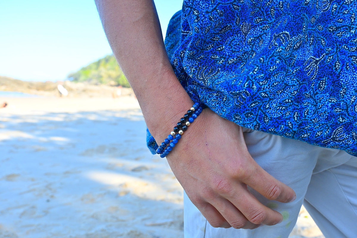 The Architect bracelet worn on a man's wrist at the beach