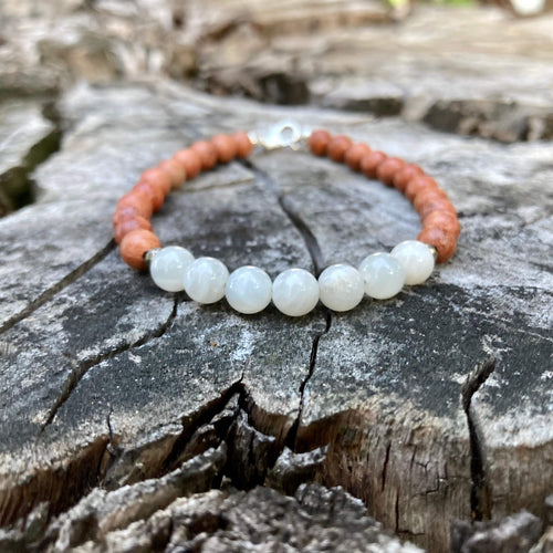 Balance men's bracelet: white moonstone with warm natural wood beads, on a weathered stump