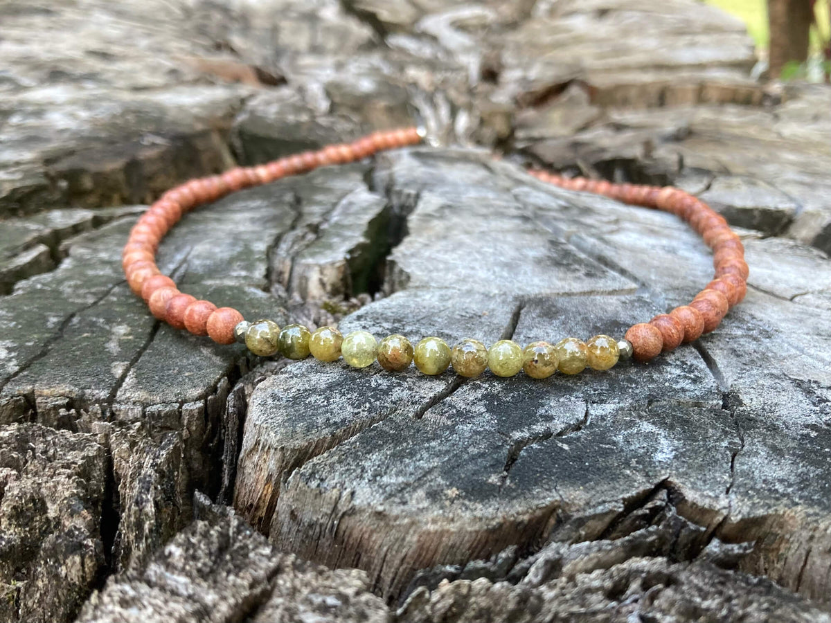 Close-up of olive-green garnet beads on the Growth necklace