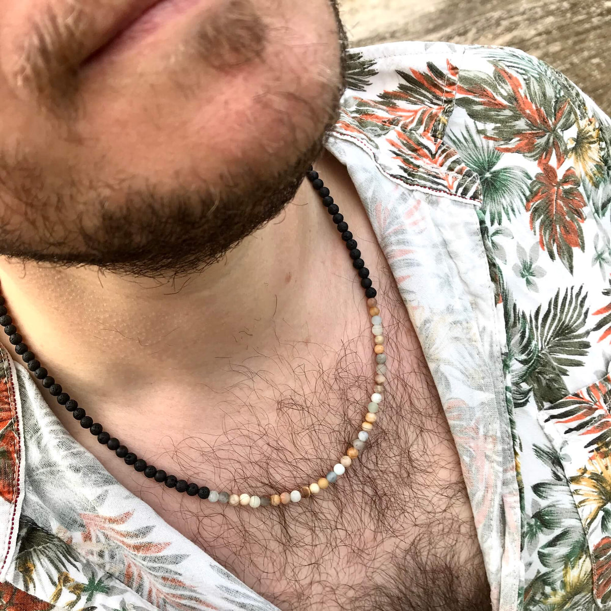 Close-up of the Vitality necklace worn with an open floral shirt