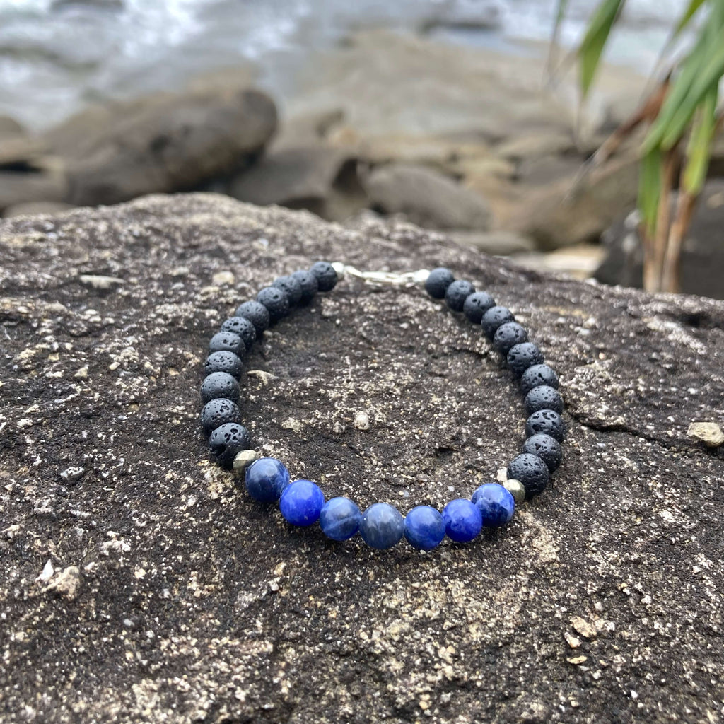 Focus bracelet on a coastal rock with plants behind