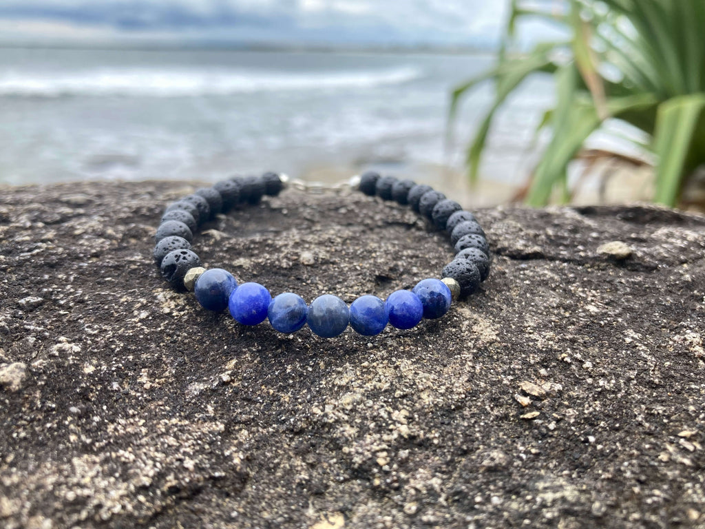 Focus bracelet on a rock by the sea with palm leaves behind