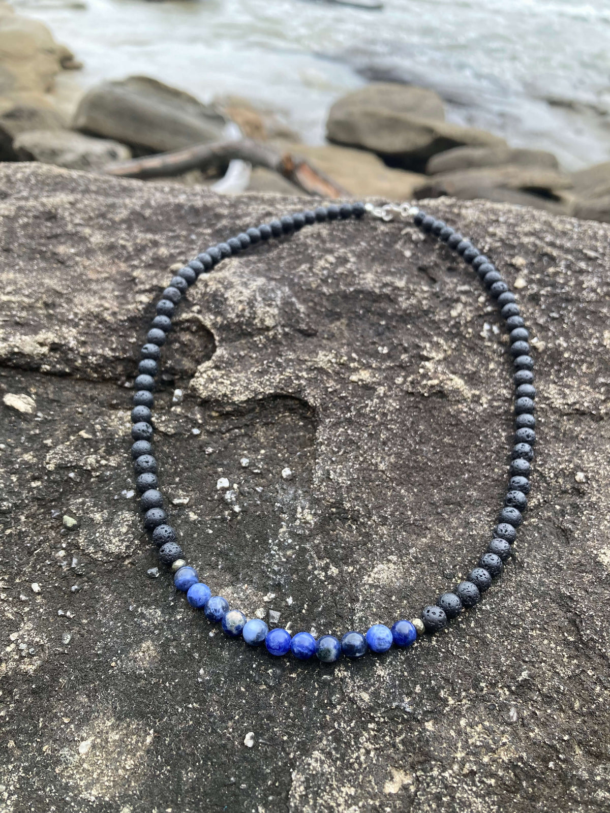 Focus necklace on a rock with rock pools behind