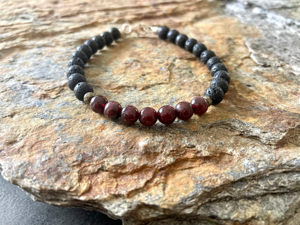 Garnet and lava stone men's bracelet on golden sandstone
