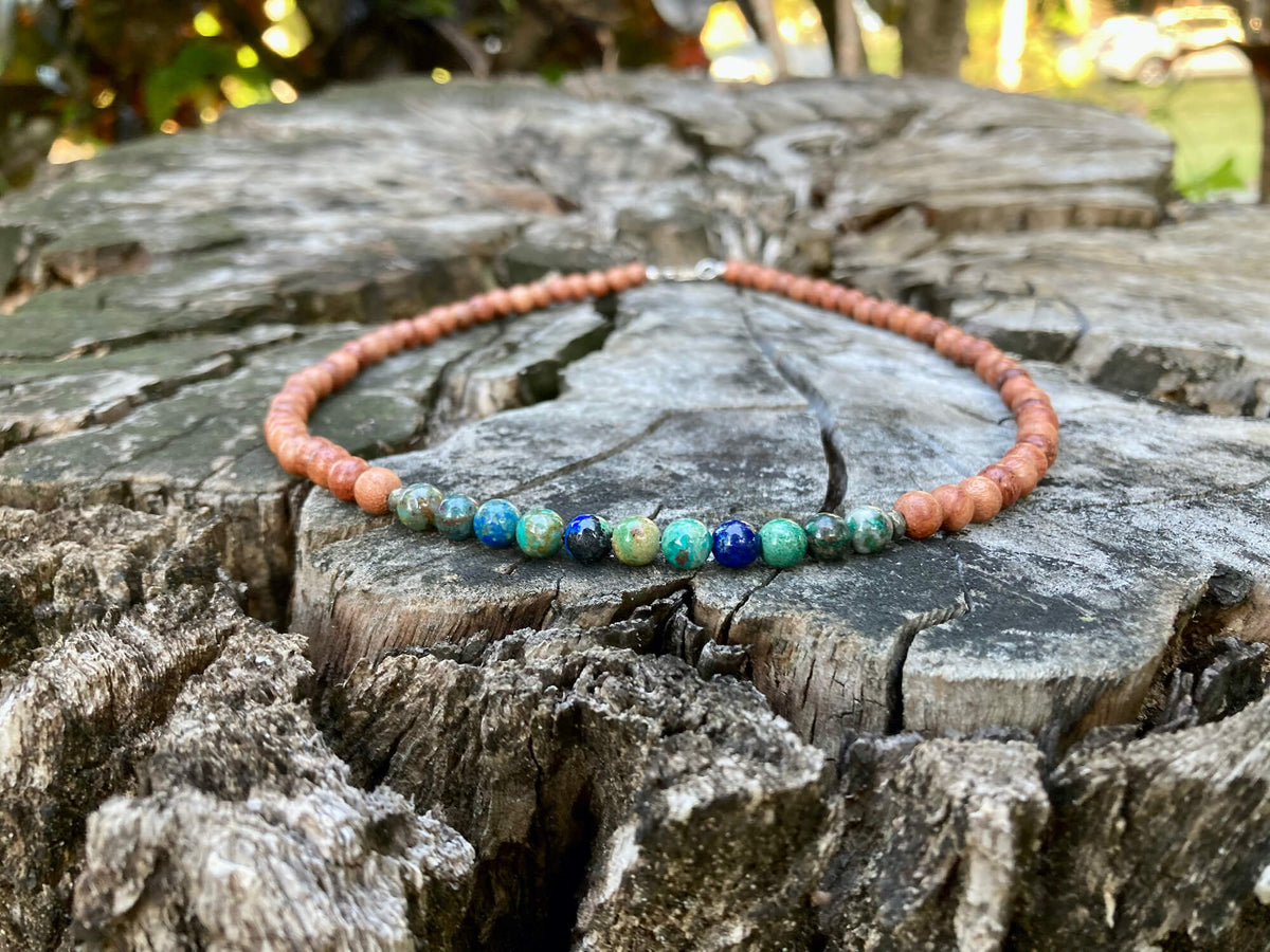 Inner Wisdom necklace on old timber with trees behind