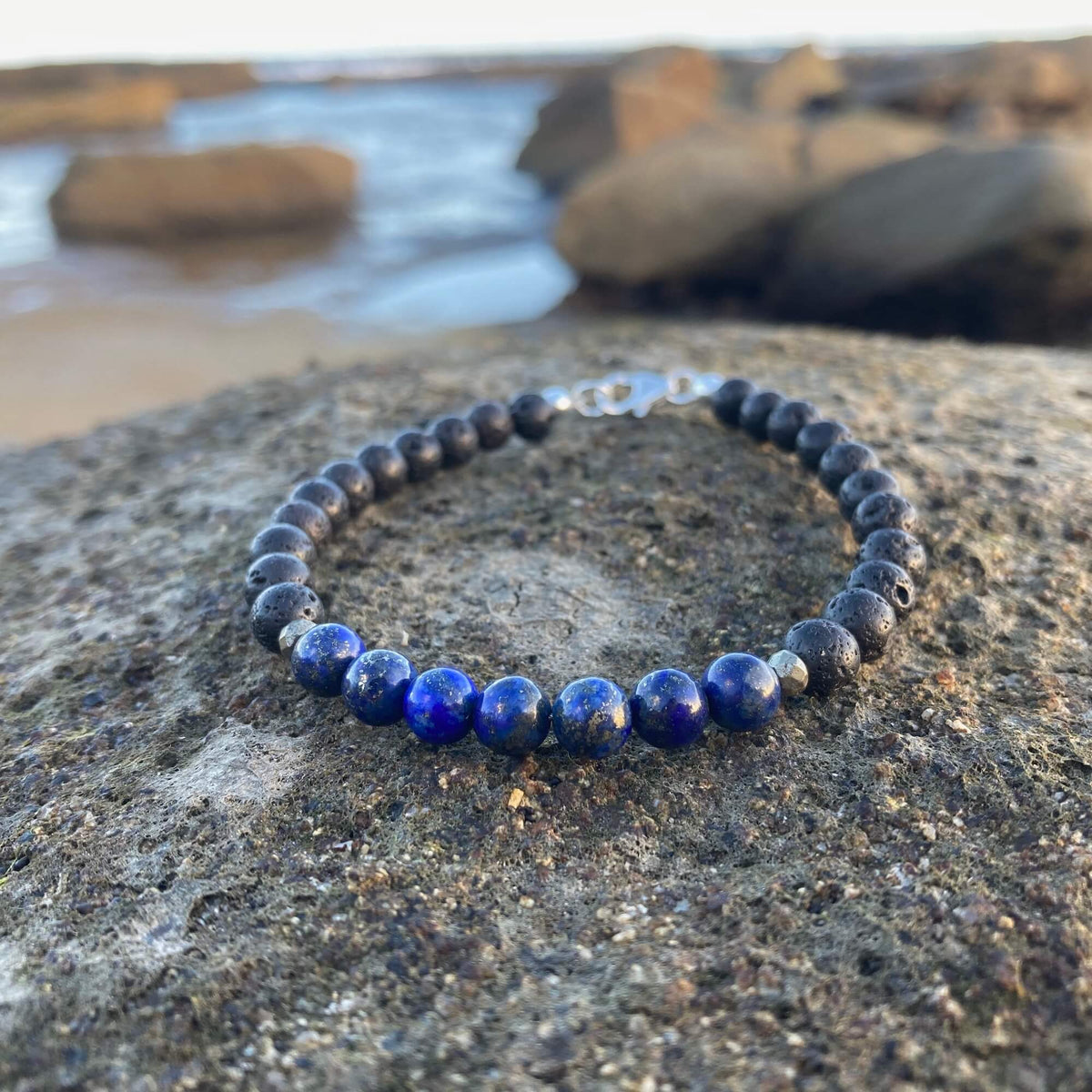 Lapis lazuli beads with gold flecks on the Self-Awareness bracelet, on volcanic rock