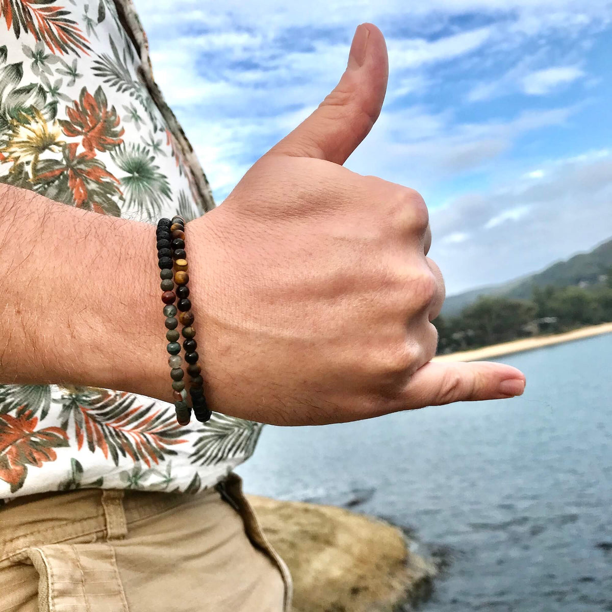 Man giving a shaka by the water, wearing the Conviction bracelet