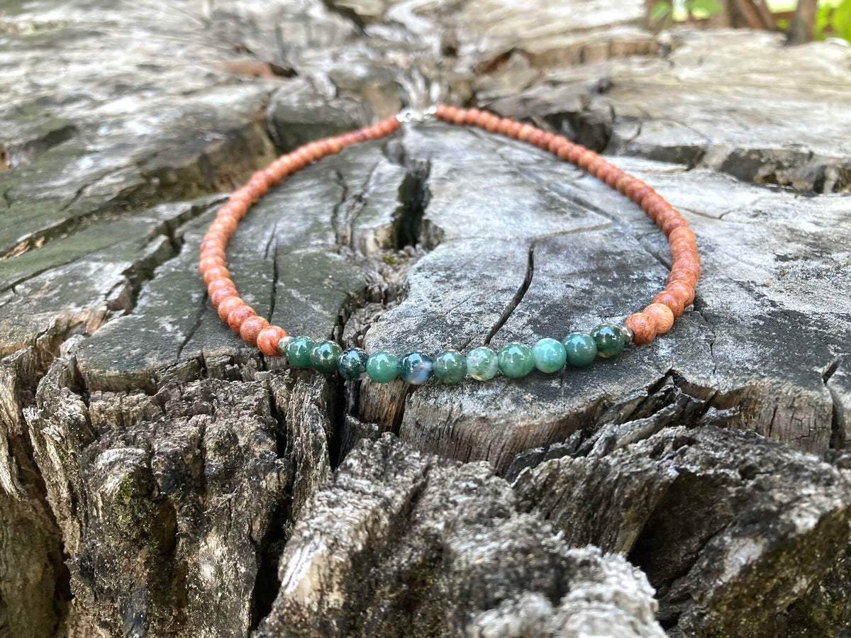 Moss agate section of the New Beginnings necklace on weathered wood