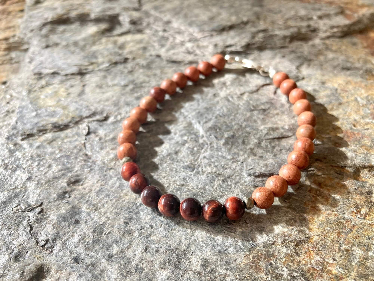 Motivation bracelet on grey stone, red tiger's eye beads at the front