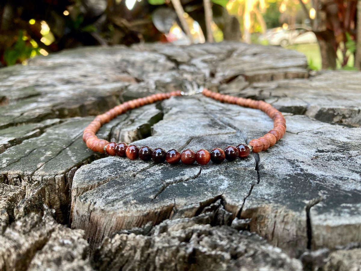 Motivation necklace on a cracked tree stump with trees behind