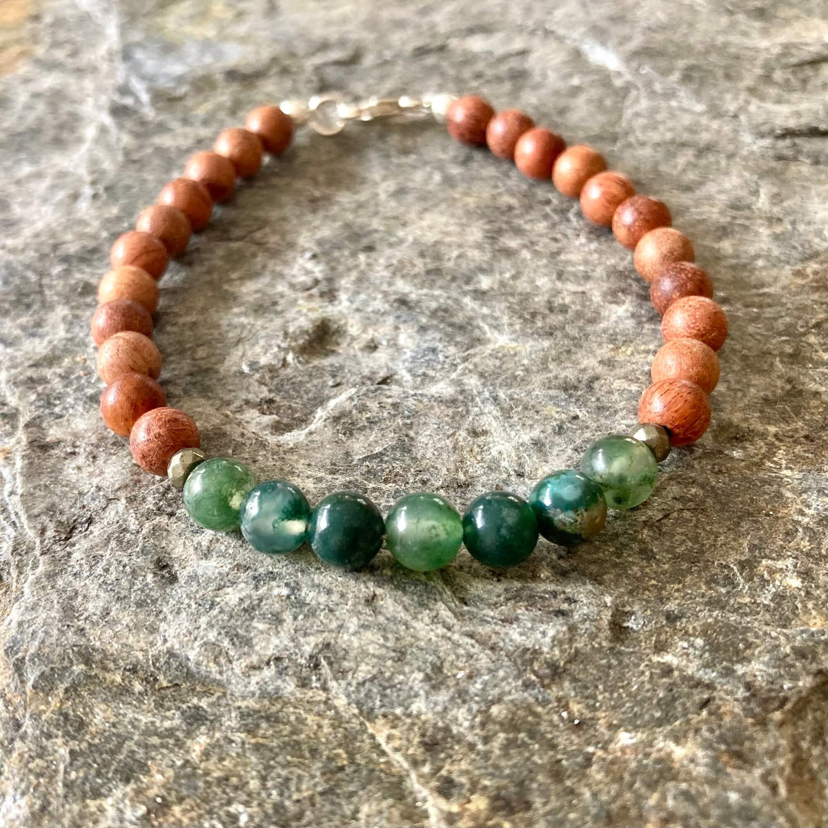 New Beginnings bracelet on grey stone, moss agate beads at the front