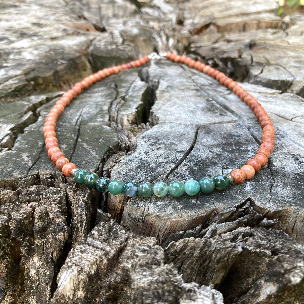 New Beginnings necklace on old timber, sterling silver clasp at the top
