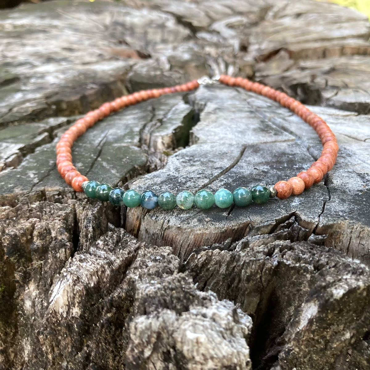 New Beginnings necklace on a stump, seen from further back