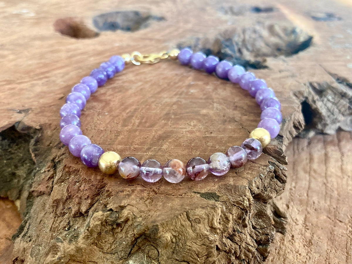 Phosphosiderite and lodolite men's bracelet resting on weathered wood