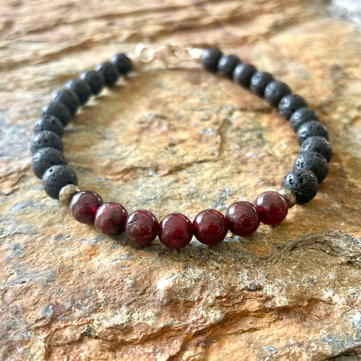 Prosperity bracelet on orange-veined sandstone, garnet beads at the front