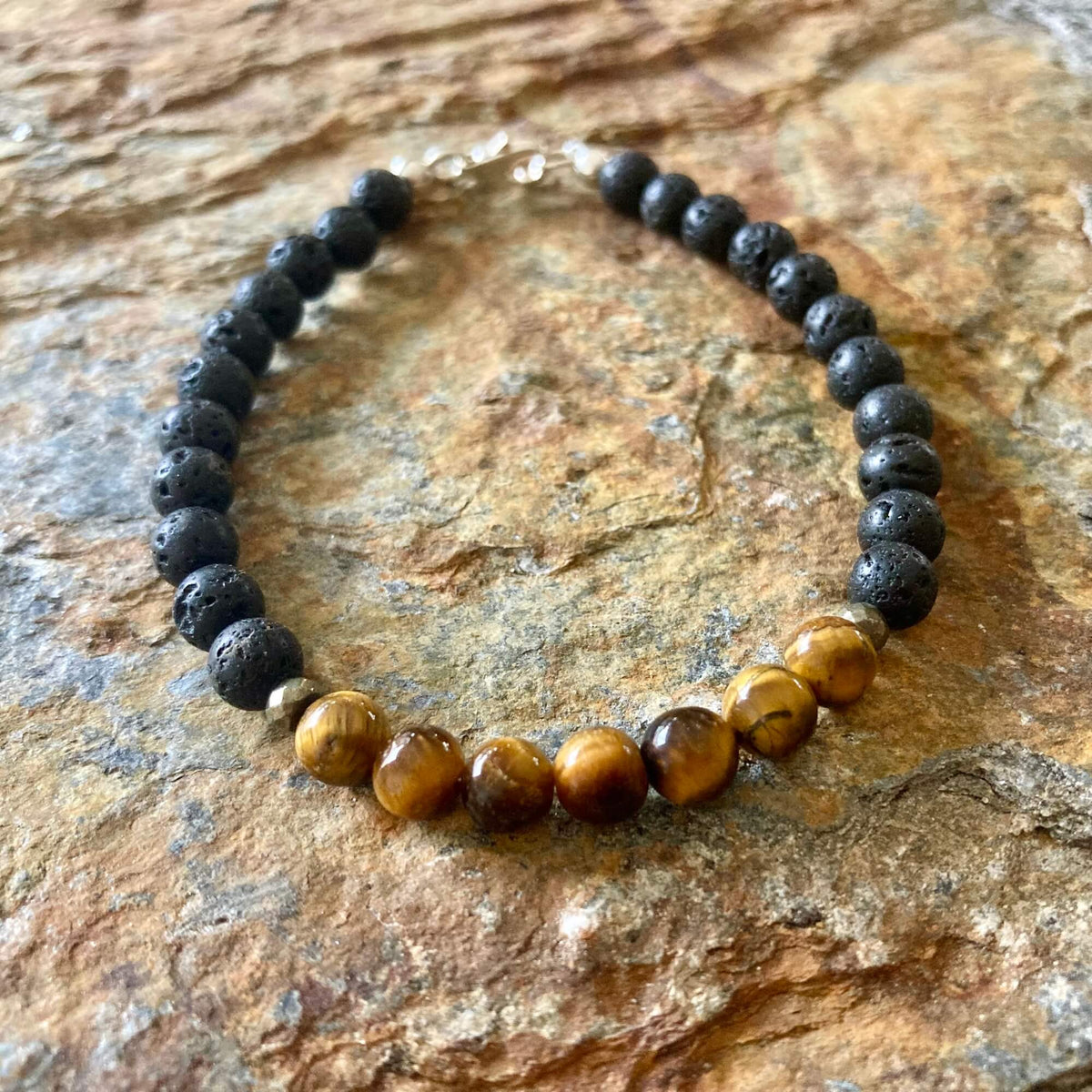 Protection bracelet from above on sandstone, sterling silver clasp at the top