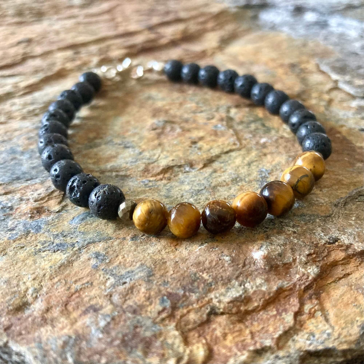 Protection bracelet on orange-veined sandstone, tiger's eye beads at the front