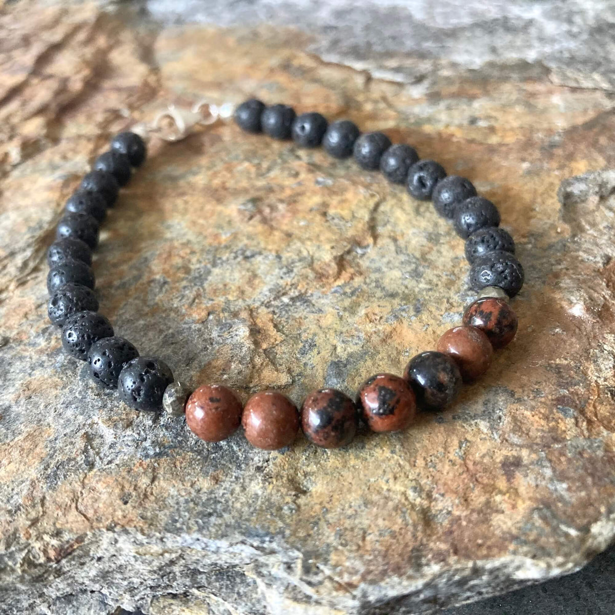 Self-Acceptance bracelet on orange-veined sandstone, red obsidian beads at the front