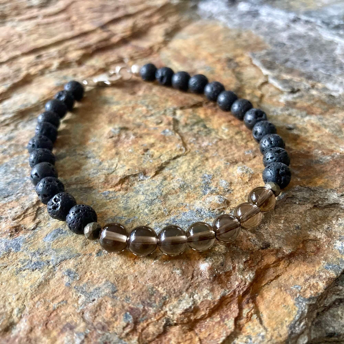 Self-Assurance bracelet on orange-veined sandstone, smoky quartz beads at the front