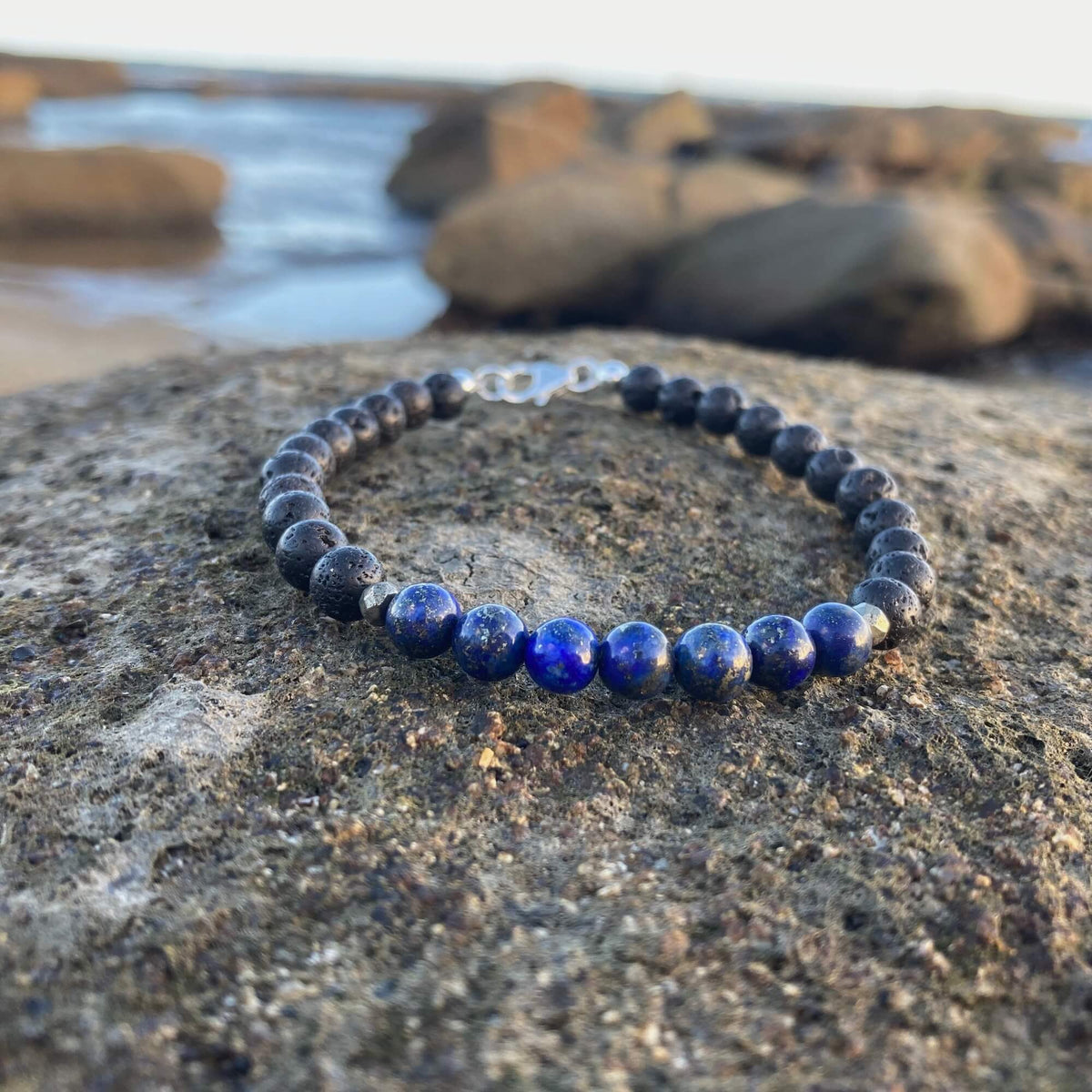 Self-Awareness bracelet on dark rock with rock pools behind, sterling silver clasp at the top