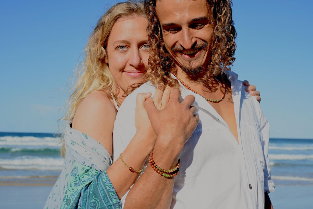 Smiling couple at the beach, the man wearing the Growth bracelet