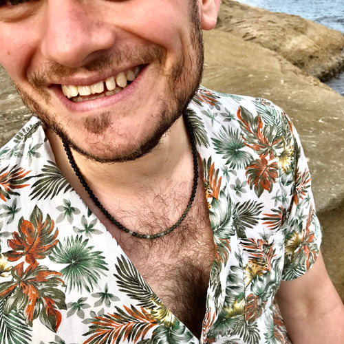 Smiling man in a floral shirt wearing the Conviction necklace