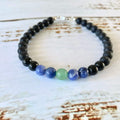 Stillness men's bracelet: black tourmaline with blue sodalite and a green aventurine centre bead, on white timber