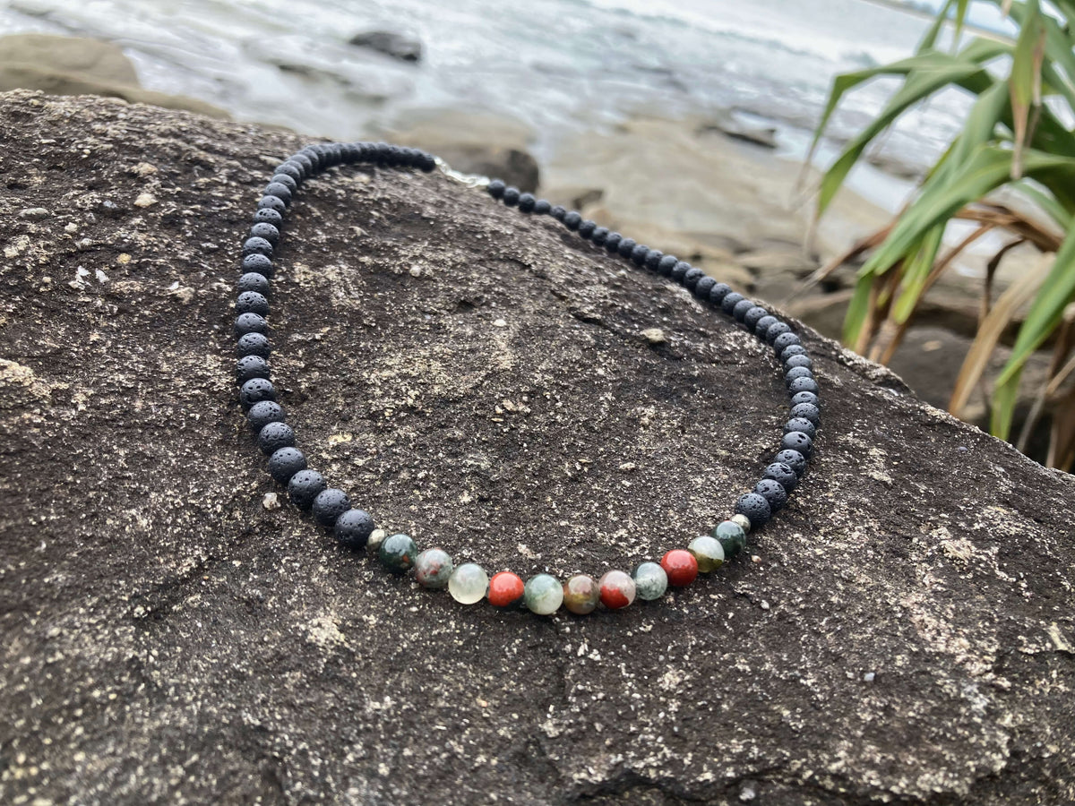 Strength necklace on a coastal rock with grasses behind