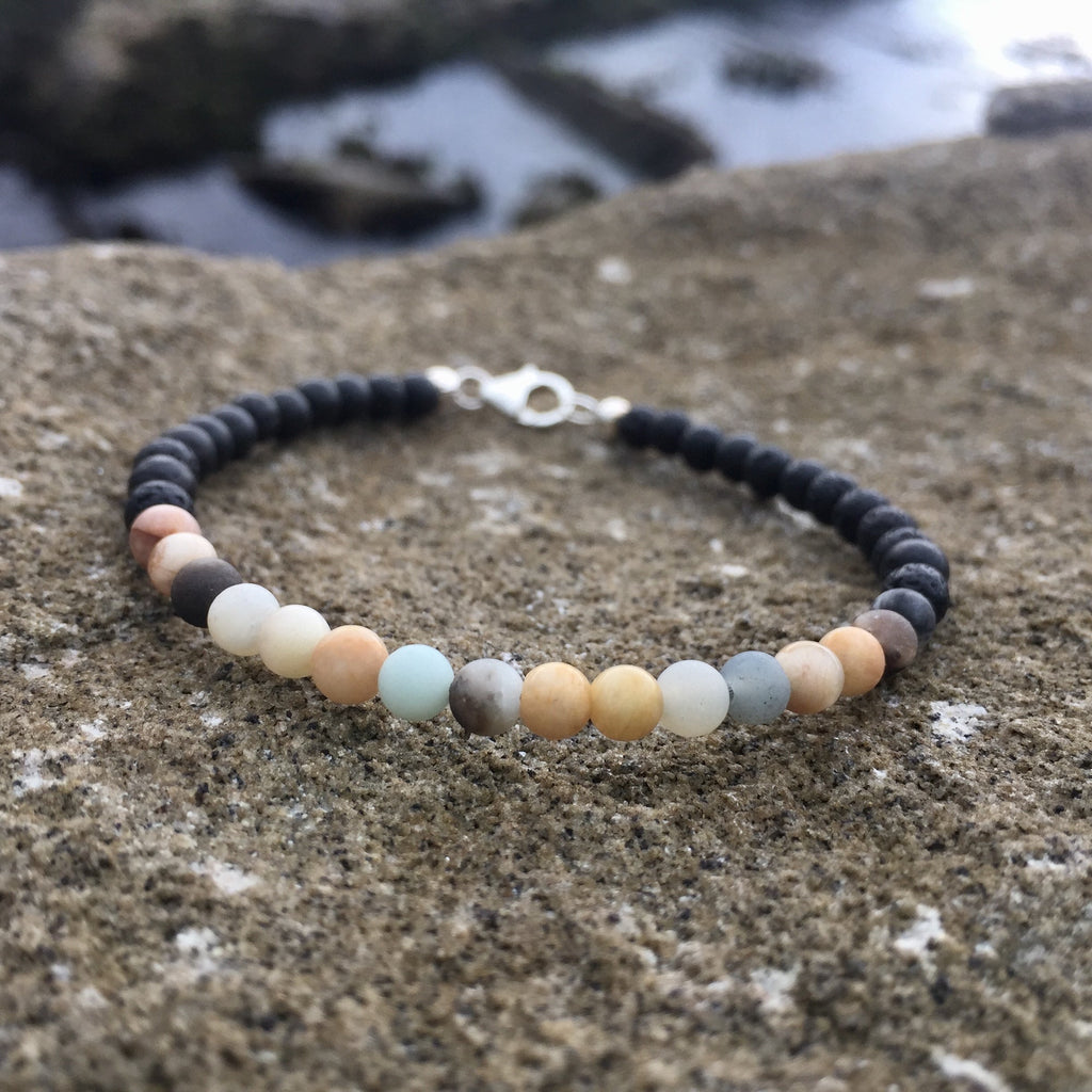 Sunstone and amazonite beads on the Vitality bracelet, on sandstone
