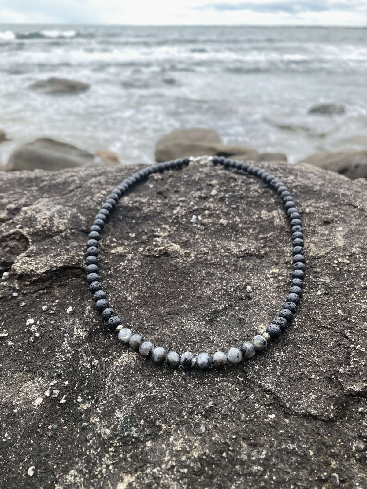 Transformation necklace on rock, seen from further back
