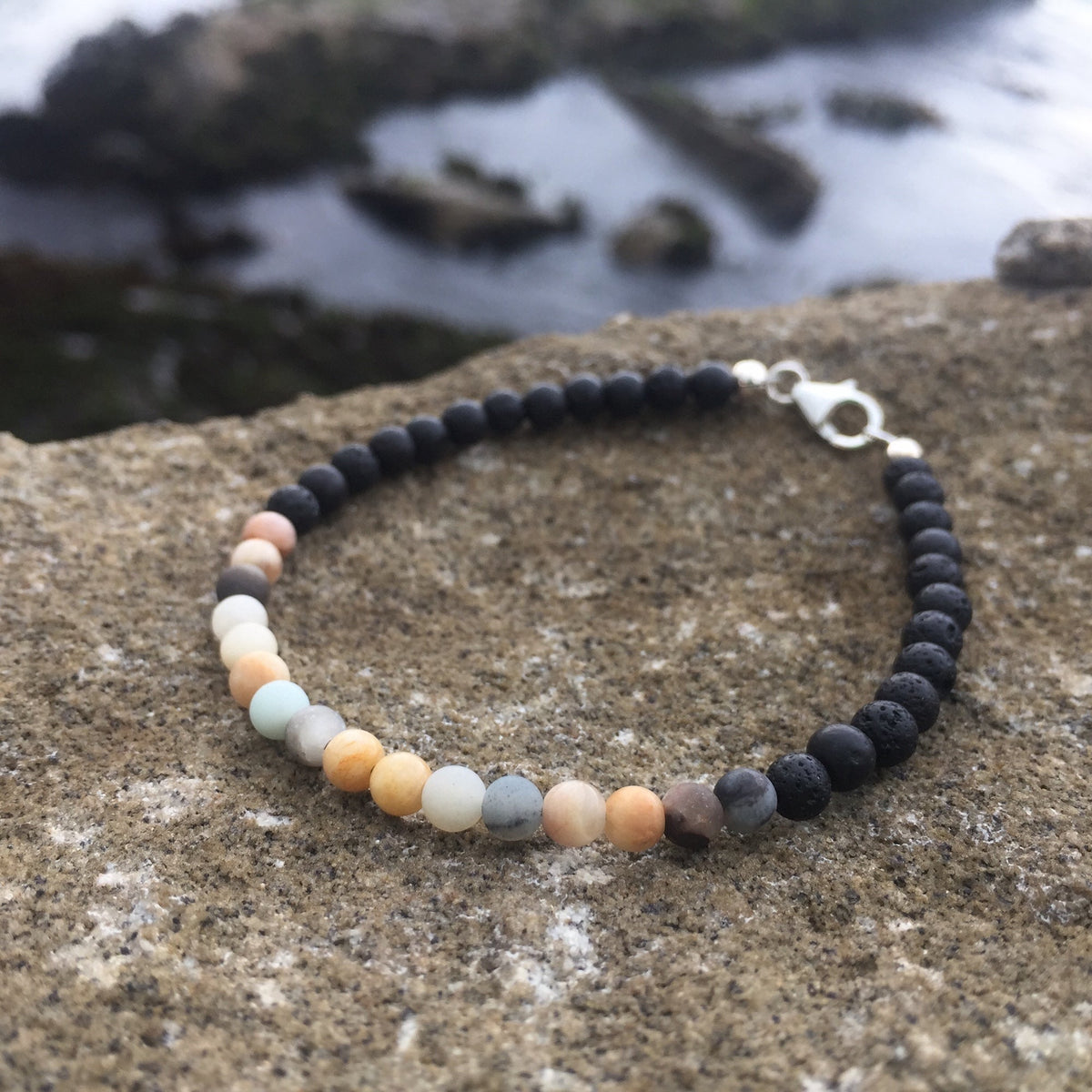 Vitality sunstone and amazonite bracelet on rock, seen from above